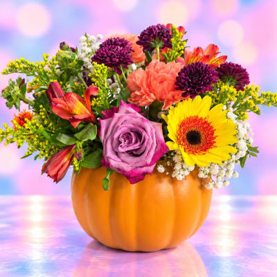 Mixed bouquet in a pumpkin-shaped orange container with bright flowers