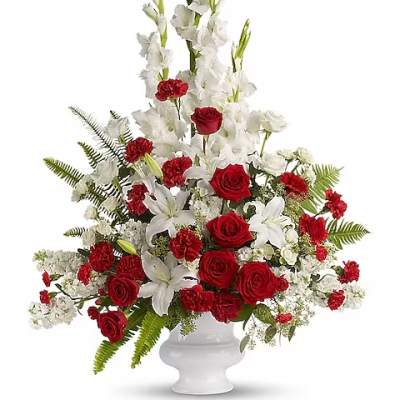 Red roses and white lilies in a white pedestal vase