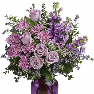 Lavender roses and purple flowers in a purple glass vase