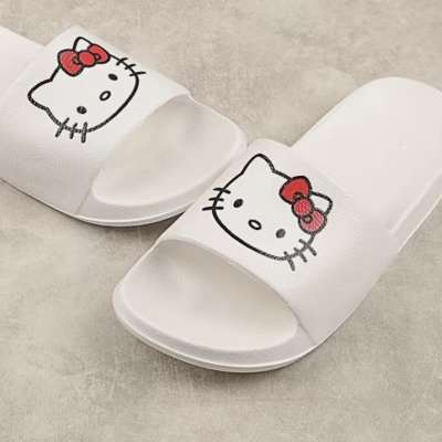 Pair of white slide sandals with Hello Kitty faces on the straps