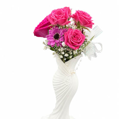 Pink roses and a purple daisy in a white vase