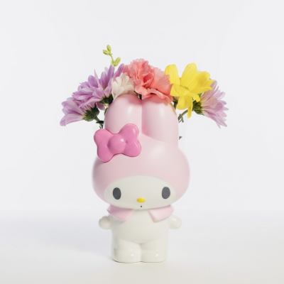 Pink Hello Kitty figurine holding a small bouquet of colorful flowers