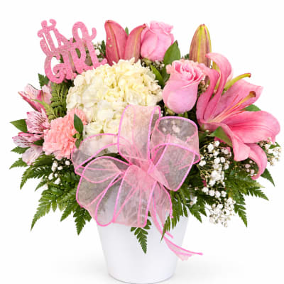 Pink and white mixed flower arrangement in a white vase with a "It's a Girl" sign