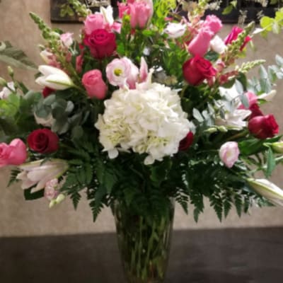 Pink and white mixed flower arrangement in a glass vase