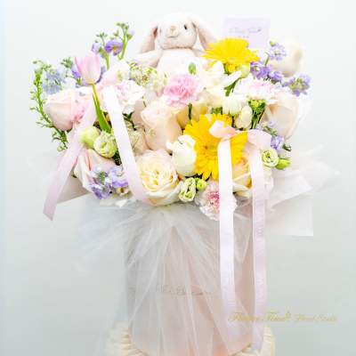Pastel flower bouquet with a plush bunny and ribbons