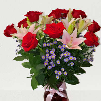 Bouquet of red roses and pink lilies in a glass vase