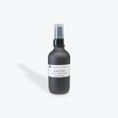 Black room spray bottle with a clear cap and white label