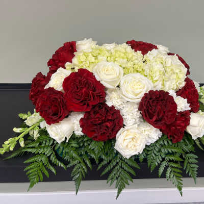 Red and white rose arrangement with white hydrangeas and greenery
