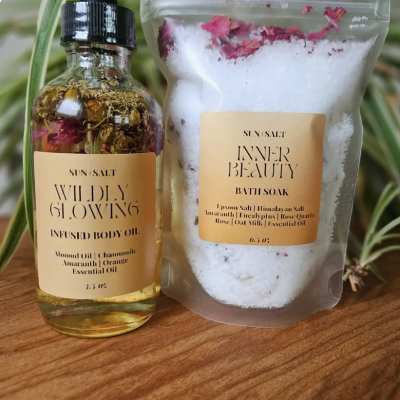 Body oil bottle and bath soak pouch on a wooden surface