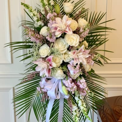 Tall floral standing spray with white and pink blooms on a metal easel