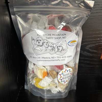 Clear bag of assorted wrapped taffy candies with holiday label