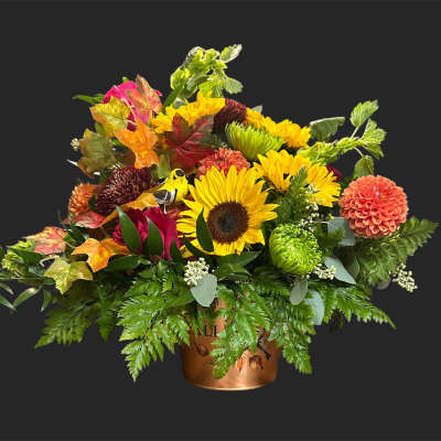 Mixed autumn bouquet with sunflowers and dahlias in a copper container
