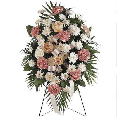 Standing floral spray with pink carnations and white daisies on a metal easel