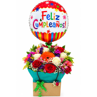 Birthday balloon above a colorful mixed flower arrangement in a gift bag