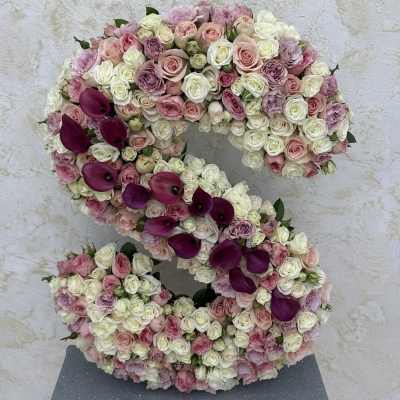 Large floral number sculpture covered in pink, white, and purple blooms