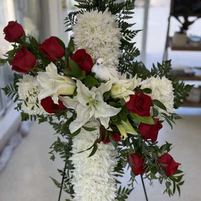 Standing floral spray with red roses and white lilies on a cross-shaped base