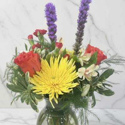 Bouquet of yellow and red flowers in a glass vase