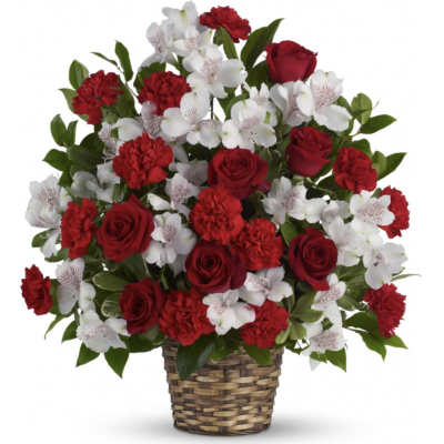 Red roses and carnations with white alstroemeria in a woven basket