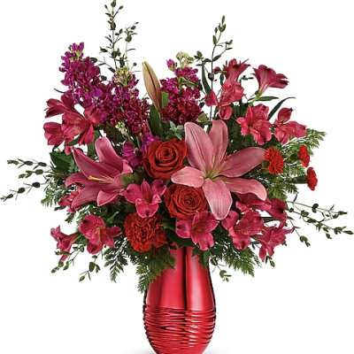Pink and red mixed flower arrangement in a red vase