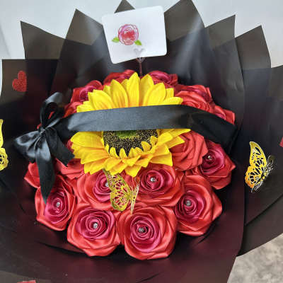Bouquet of red roses and a yellow sunflower wrapped in black paper