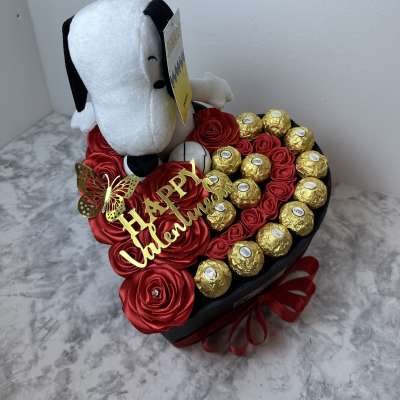 Heart-shaped gift box with red roses, chocolates, and a Snoopy plush