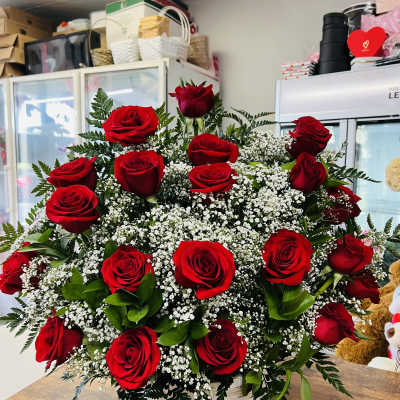 Basket arrangement of red roses with white filler flowers