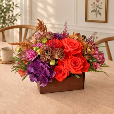 Colorful flower arrangement in a wooden box on a table