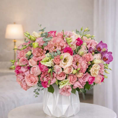 Large pink and white flower arrangement in a white vase