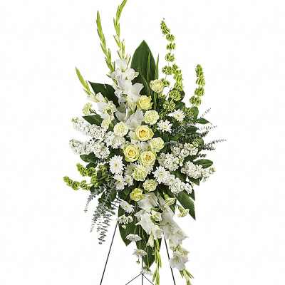 Tall white and pale yellow funeral spray on a stand