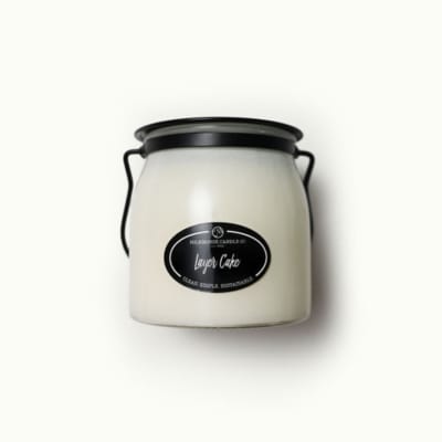 White candle in a black-lidded jar with a handle