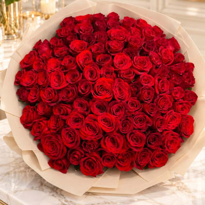 Large bouquet of red roses wrapped in cream paper