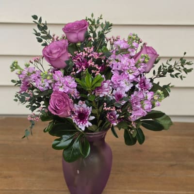 Purple roses and mixed pink flowers in a purple vase