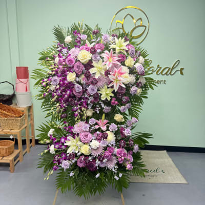 Large standing floral spray with pink, purple, and white blooms