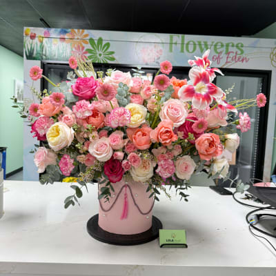 Large pink and peach floral arrangement in a pink hatbox