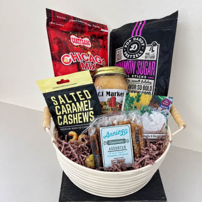 Gift basket with assorted snack bags and a jar in a white bowl