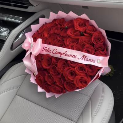 Heart-shaped bouquet of red roses with a pink ribbon in a car seat