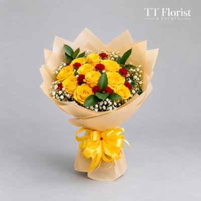 Bouquet of yellow roses with red accents wrapped in beige paper