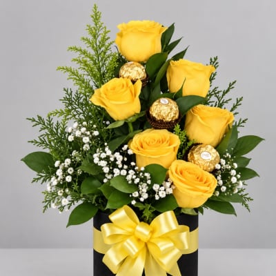Yellow roses in a black gift box with a yellow ribbon and chocolates