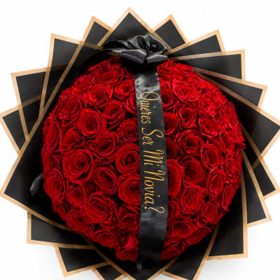 Heart-shaped bouquet of red roses wrapped in black paper with a ribbon