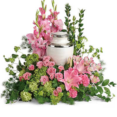 Pink flowers arranged around a white urn with green foliage