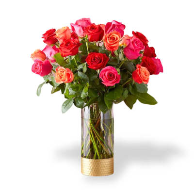 Bouquet of red, pink, and peach roses in a clear glass vase
