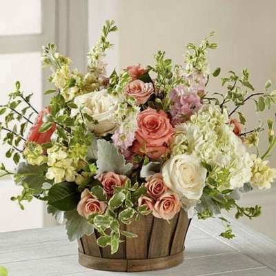 Mixed bouquet of pink and white flowers in a wooden basket