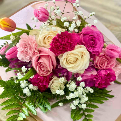 Pink and cream roses with tulips and carnations in a bouquet