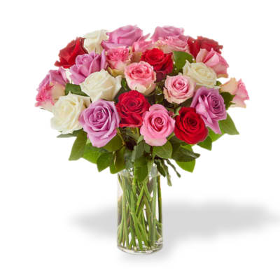 Bouquet of pink, red, and white roses in a clear glass vase