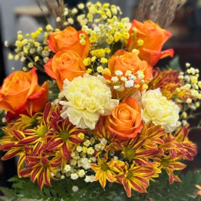 Bouquet of orange roses, cream carnations, and striped chrysanthemums