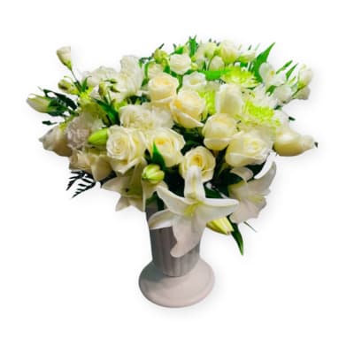 White roses and lilies arranged in a silver vase