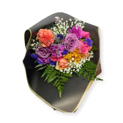 Mixed bouquet of roses, carnations, and small white filler flowers in dark wrapping
