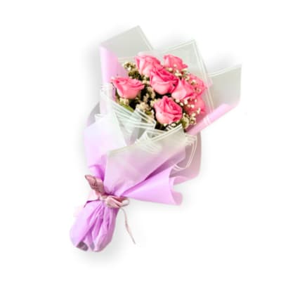 Pink roses wrapped in lavender and clear paper with a ribbon