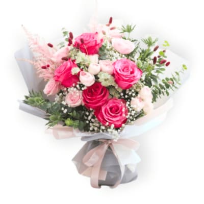 Bouquet of pink and red roses wrapped in pale paper