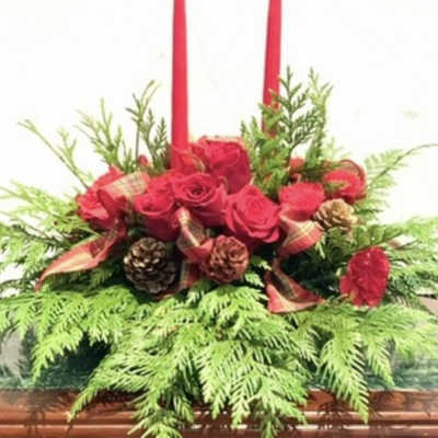 Red rose centerpiece with two tall red candles and pinecones